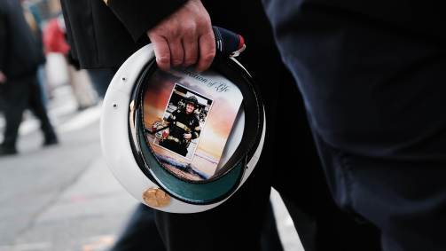 Norte-americano carrega foto de uma bombeira vítima dos ataques de 11/9 dentro de quepe militar