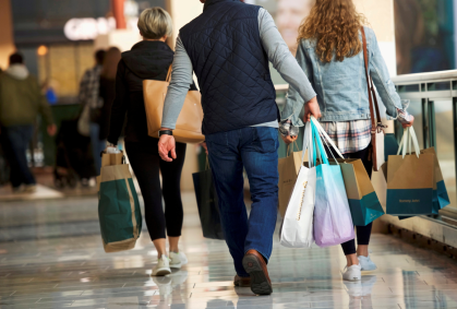 Consumidores carregam sacolas de mercadorias compradas