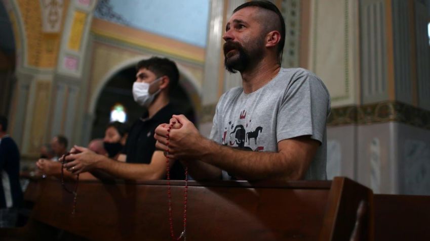 Descendentes de ucranianos e membros da “Irmandade dos Cossacos” oram o rosário dentro da igreja de São Josafá / Pilar Olivares/Reuters (3.mar.2022)