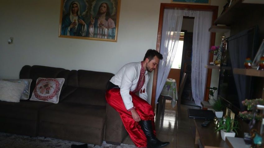 Rodrigo Michalovski veste-se no típico traje da "Irmandade dos Cossacos” / Pilar Olivares/Reuters (3.mar.2022)