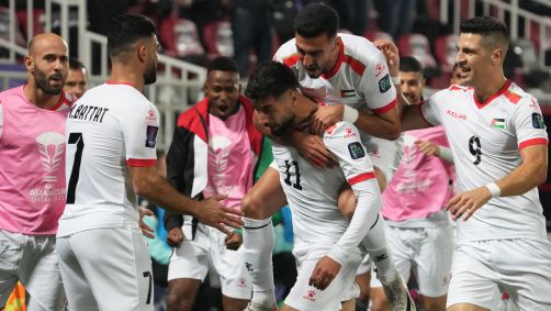 Oday Dabbagh, que marcou dois gols sobre Hong Kong, comemora com os companheiros palestinos a vitória histórica