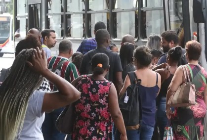 Pessoas enfileiradas para entrar no transporte público