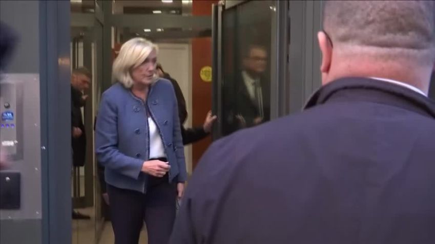 Marine Le Pen saindo da sede do Reunião Nacional. • Reuters